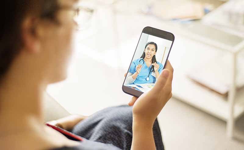 Woman having a video consultation with a nurse on her smartphone